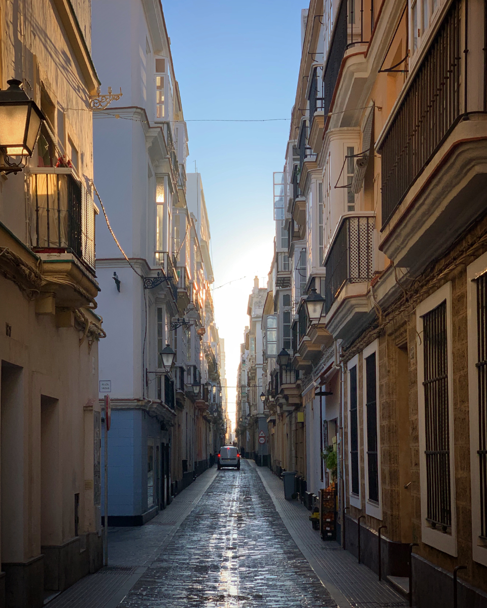 A narrow street lined with lamps and old stone buildings